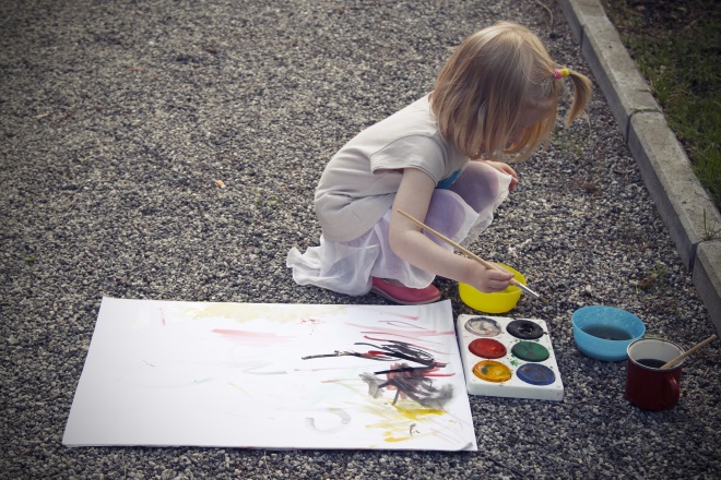 Девочка рисует на улице